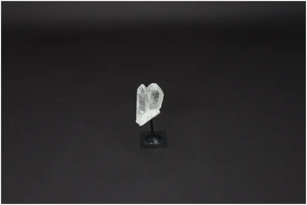 Lemurian Quartz on metal stand against dark background, showcasing clear quartz's purification qualities.