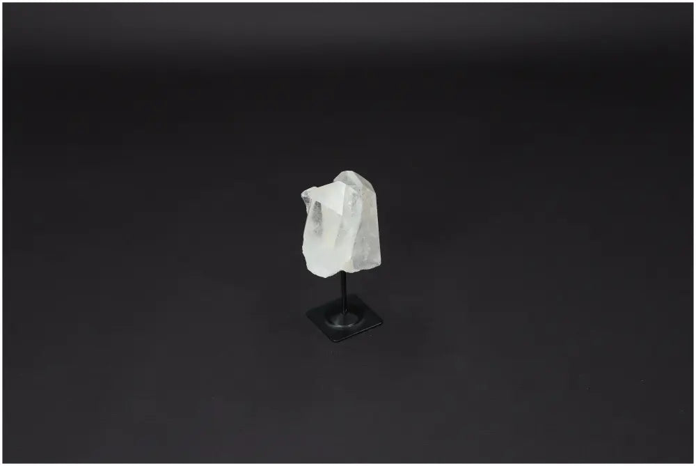 Lemurian Quartz on metal stand against dark background, known for purification and harmonizing energy, ideal for daily use and protection.