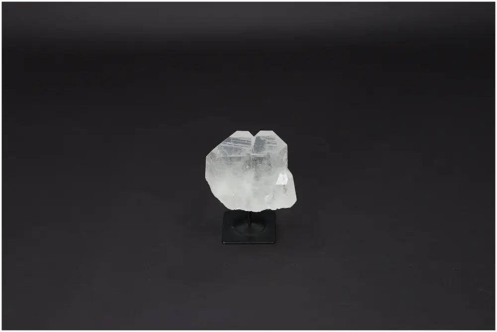 Lemurian Quartz on a black metal stand, showcasing its clear, purifying properties for harmonizing body and mind.