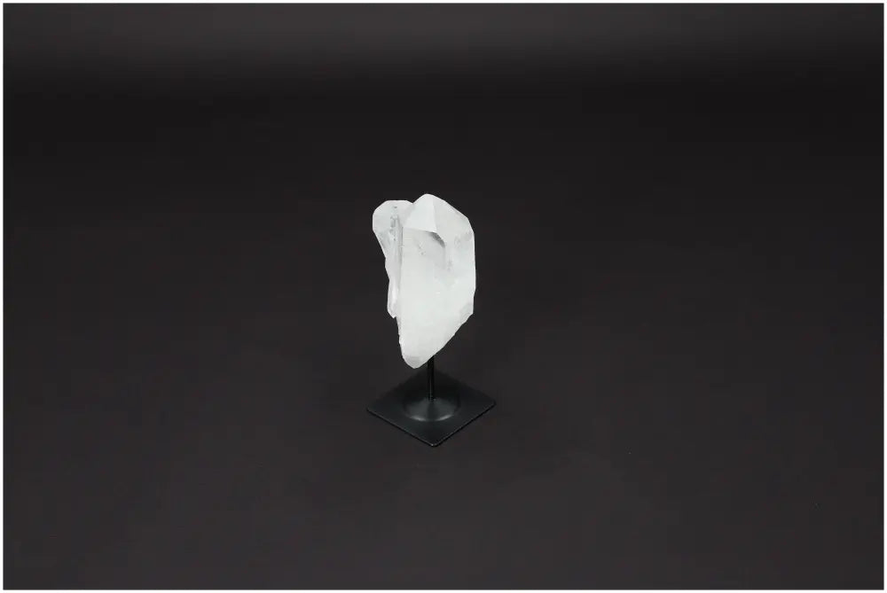 Lemurian Quartz on a metal stand against a dark background, showcasing its clarity and purification properties for energy harmonization.