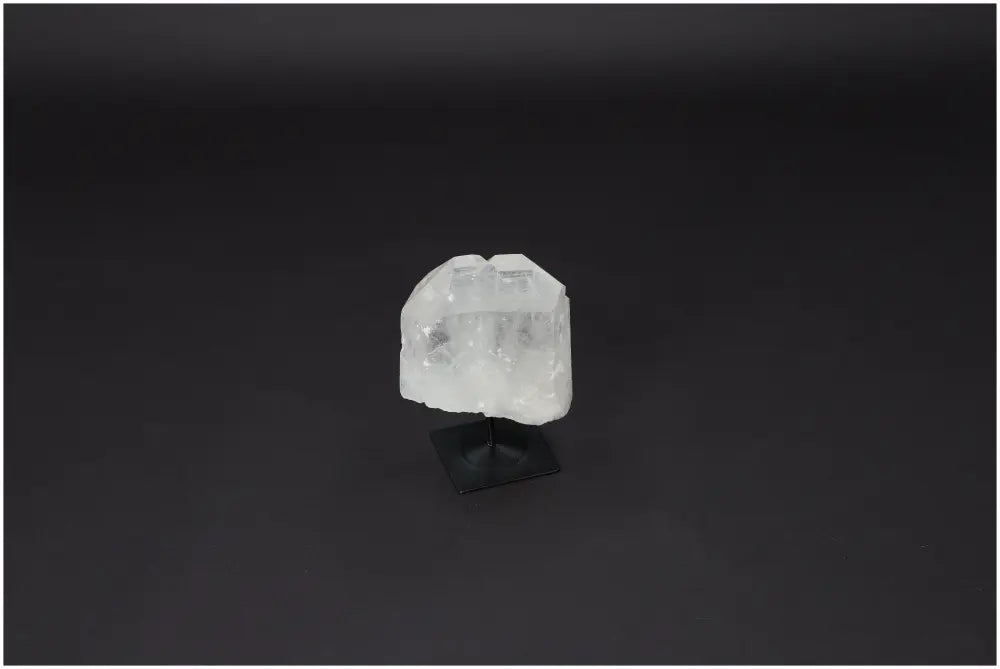Lemurian Quartz on a metal stand, ideal for purification and neutralizing negative vibrations, showcased against a dark background.