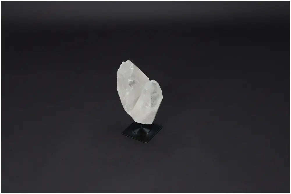 Lemurian Quartz on metal stand, known for purification and harmonizing energy, displayed on a dark background.