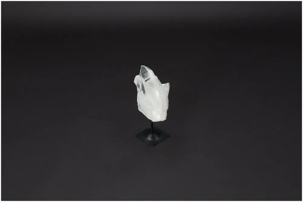 Lemurian Quartz on metal stand against dark background, symbolizing purification and balance, absorbs negative energy and soothes emotions.