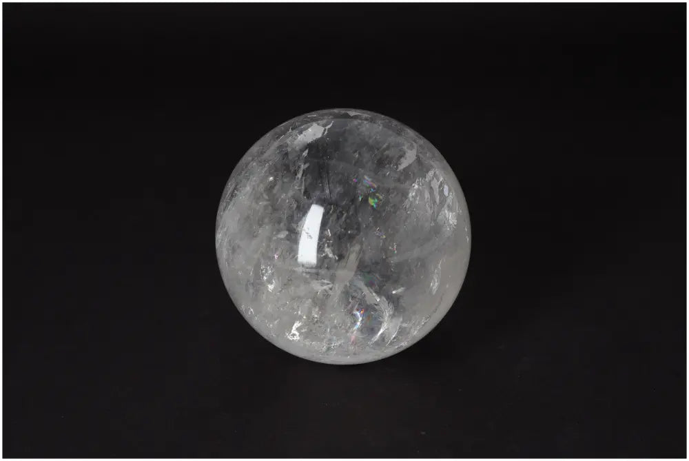 Lemurian Quartz Sphere 8-9 CM with radiant clarity on black background, promoting intuition and spiritual growth.