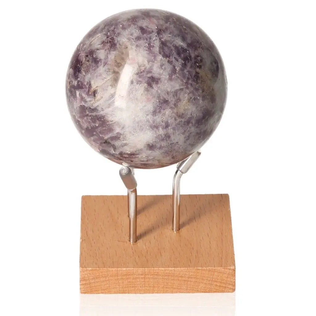 Lepidolite sphere on a wooden stand, offering peace and emotional balance, ideal for enhancing positivity and goal-setting.