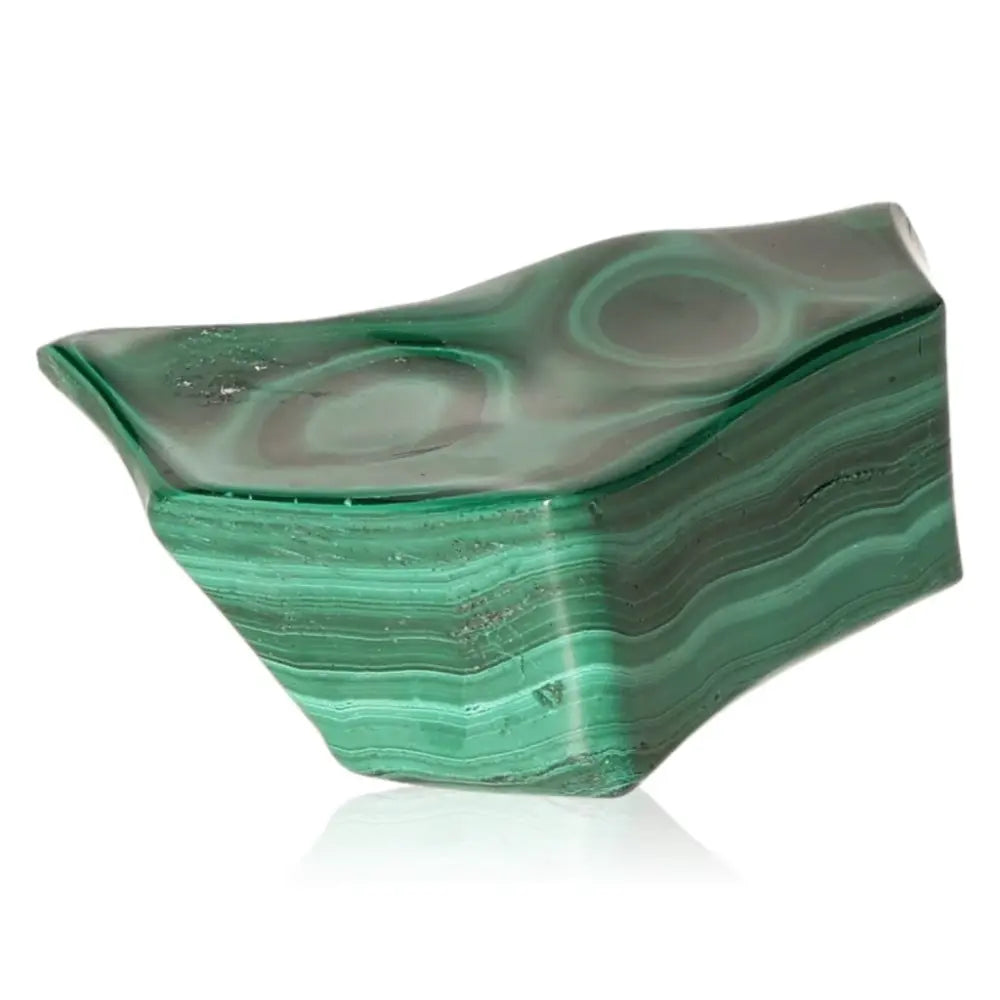 Malachite gemstone, vibrant green, known for its transformative energy and soothing properties, with unique wavy patterns.