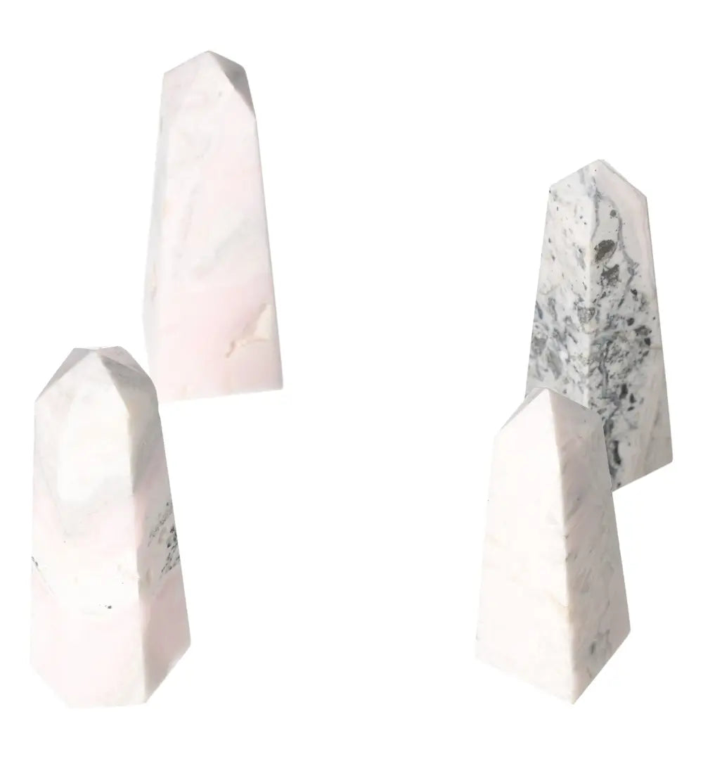 Four Manganocalcite towers, known for healing and boosting creativity, against a white background.