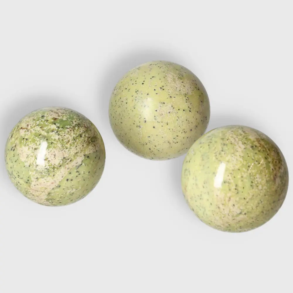 Polished medium serpentine spheres showcasing vibrant green hues and grounding energy properties, ideal for meditation and décor.