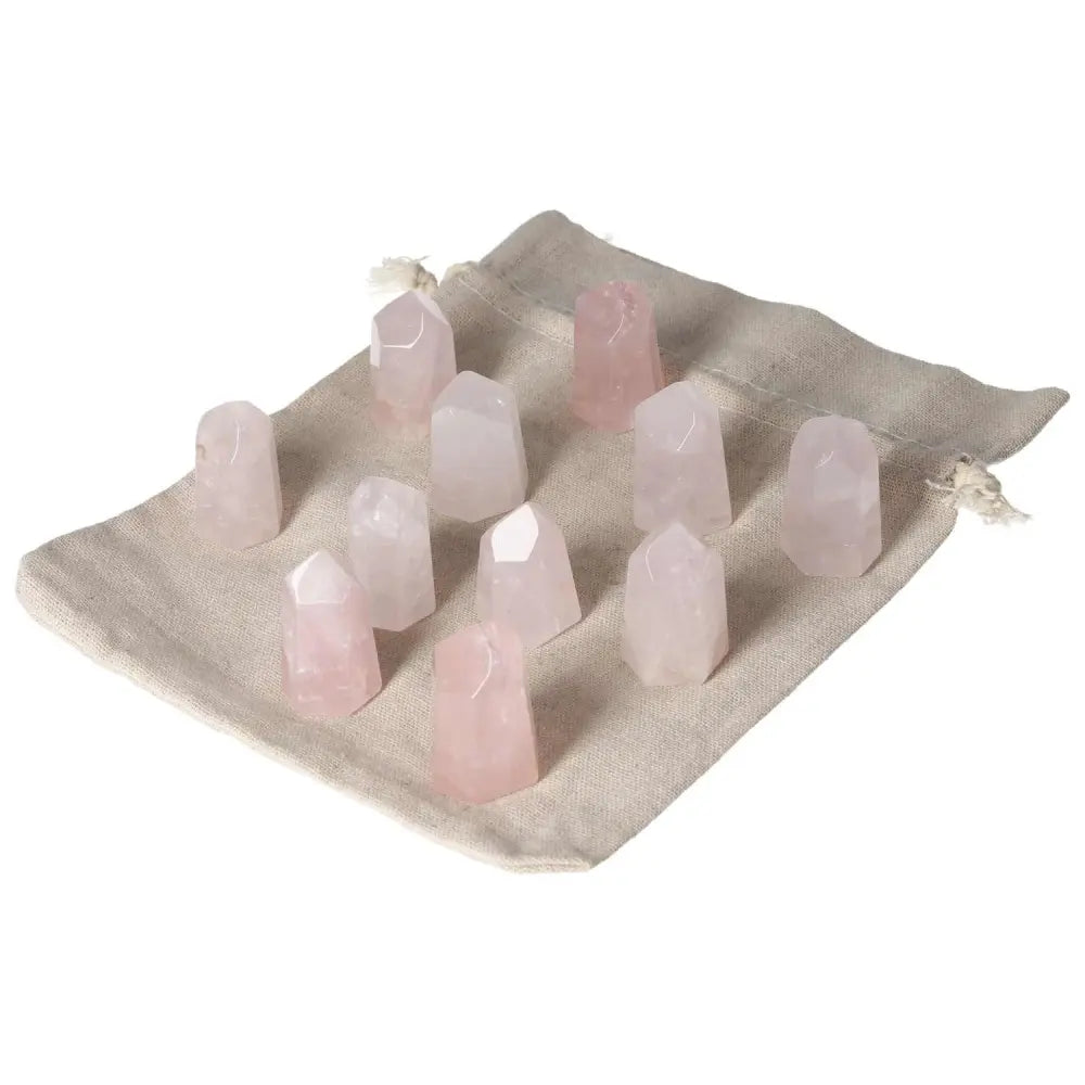Mini Point Rose Quartz stones on a beige cloth, promoting emotional healing, trust, and love with gentle energy and empathy enhancement.