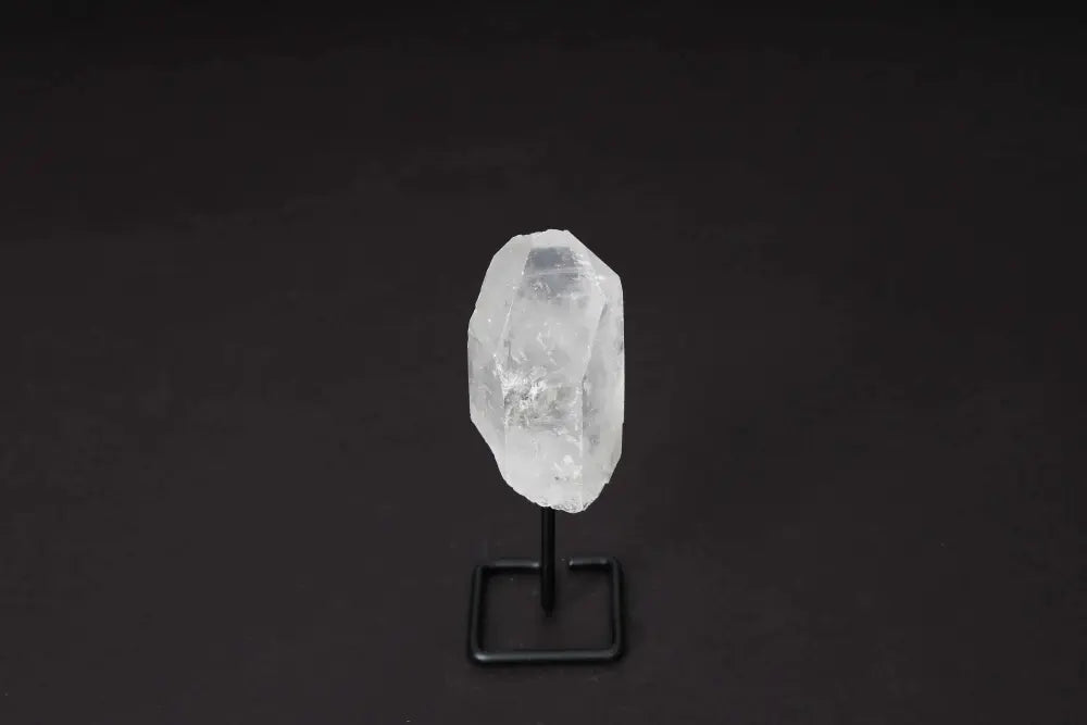 Natural Clear Quartz Point on a sleek black stand, perfect for amplifying energy and focus in meditation and energy work.
