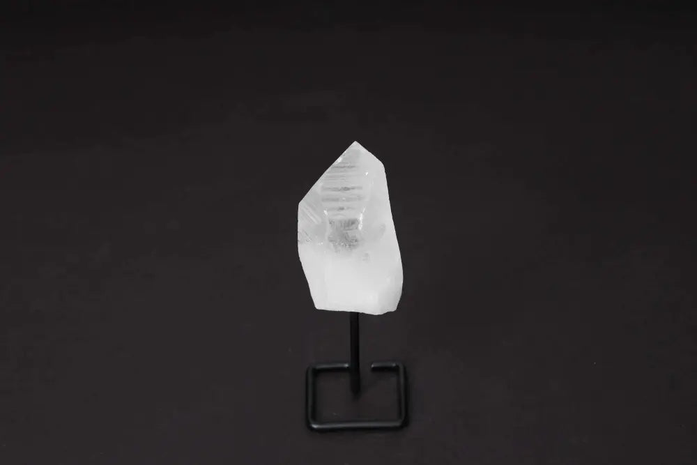 Natural clear quartz point on a modern stand for energy alignment and amplification, ideal for meditation and manifestation.