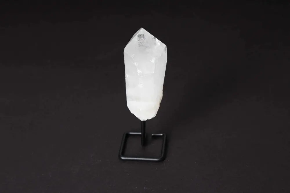 Clear Quartz Point on stand, enhances meditation, energy work with sophisticated display, known for amplifying energy and clarity.