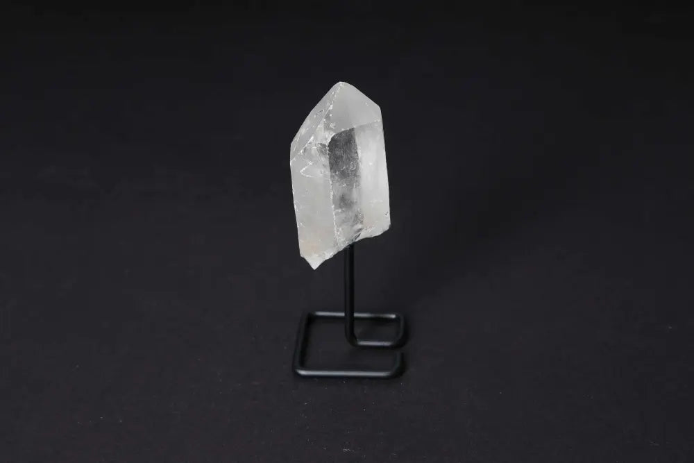 Elegant clear quartz point on a black stand, perfect for meditation and energy work, enhancing clarity and focus in modern spaces.