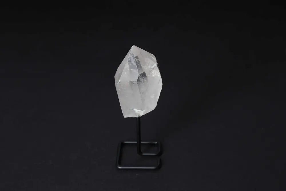 Natural Clear Quartz Point on elegant stand for energy amplification and clarity, ideal for meditation and manifestation.