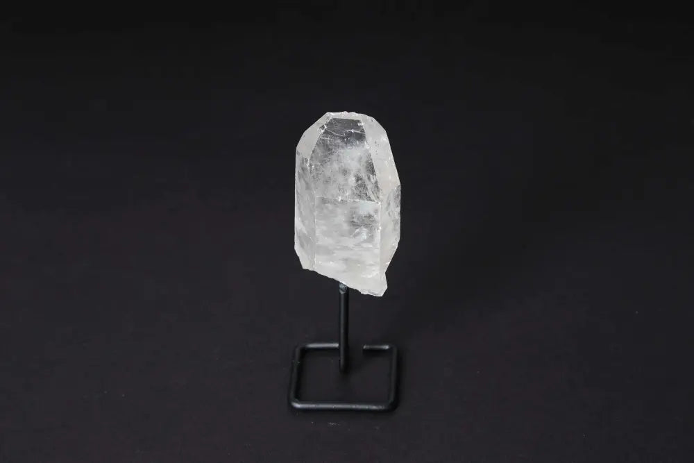 Natural clear quartz point on a stand, perfect for meditation and energy alignment, enhancing clarity and focus in any space.