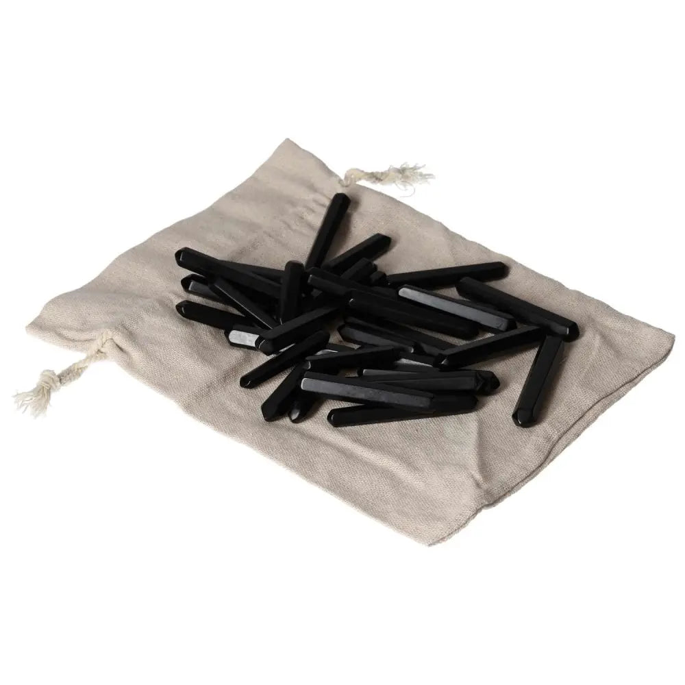 Black Obsidian Small Stics on beige cloth bag, known for powerful protective properties and neutralizing negative energy.