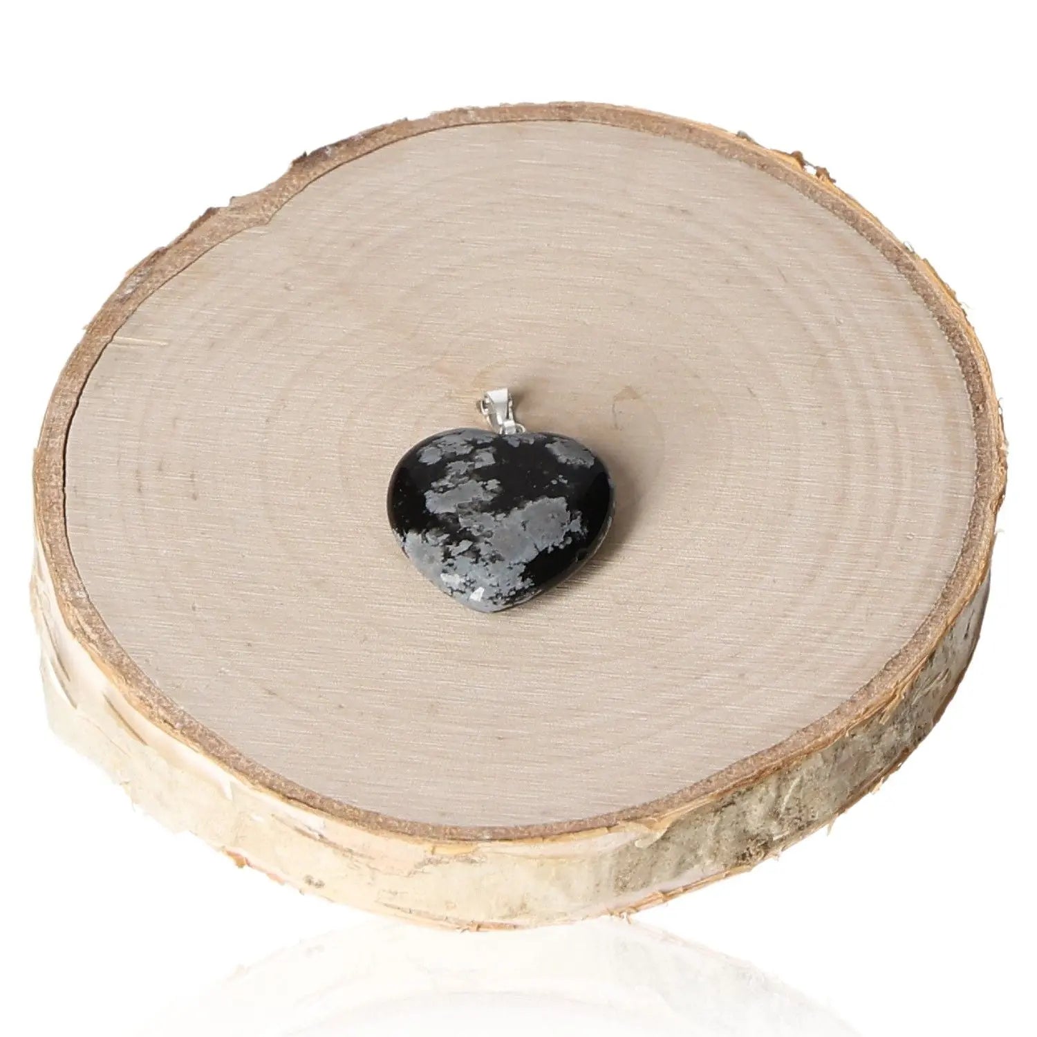 20mm Obsidian Snowflake Heart Pendant displayed on a wooden disc, illustrating unique snowflake patterns in the obsidian stone.