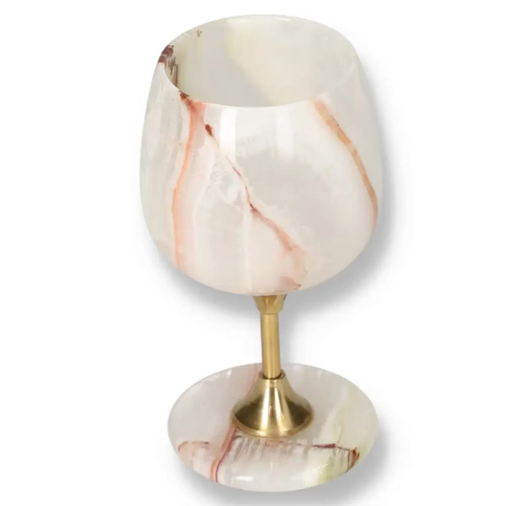 Exquisite off-white onyx wine glass with unique veining and a polished surface, featuring a gold-toned stem for elegant fine dining.
