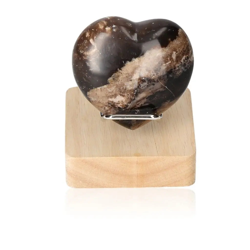 Heart-shaped opal crystal on wooden stand, symbolizes mystical power, love, and cosmic consciousness, ideal for passion and motivation.
