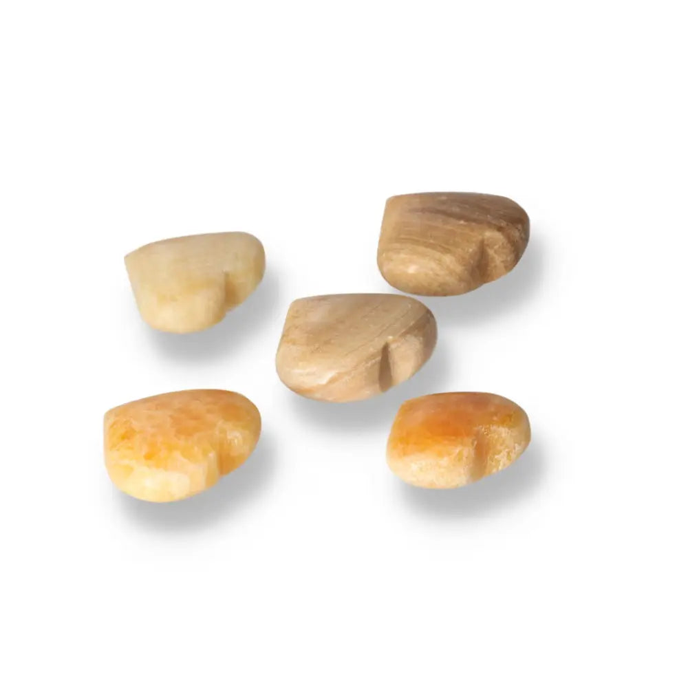 Five heart-shaped orange calcite gemstones displaying radiant beauty and vibrant energy for emotional balance and creativity.