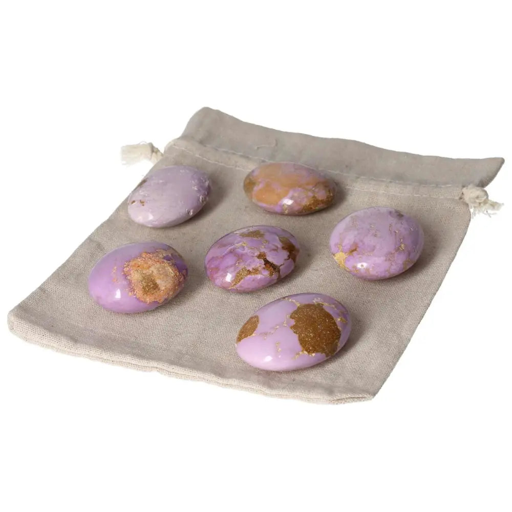 Phosphosidente palmstones on a beige fabric pouch, featuring purple hues and unique patterns, perfect for meditation and healing.