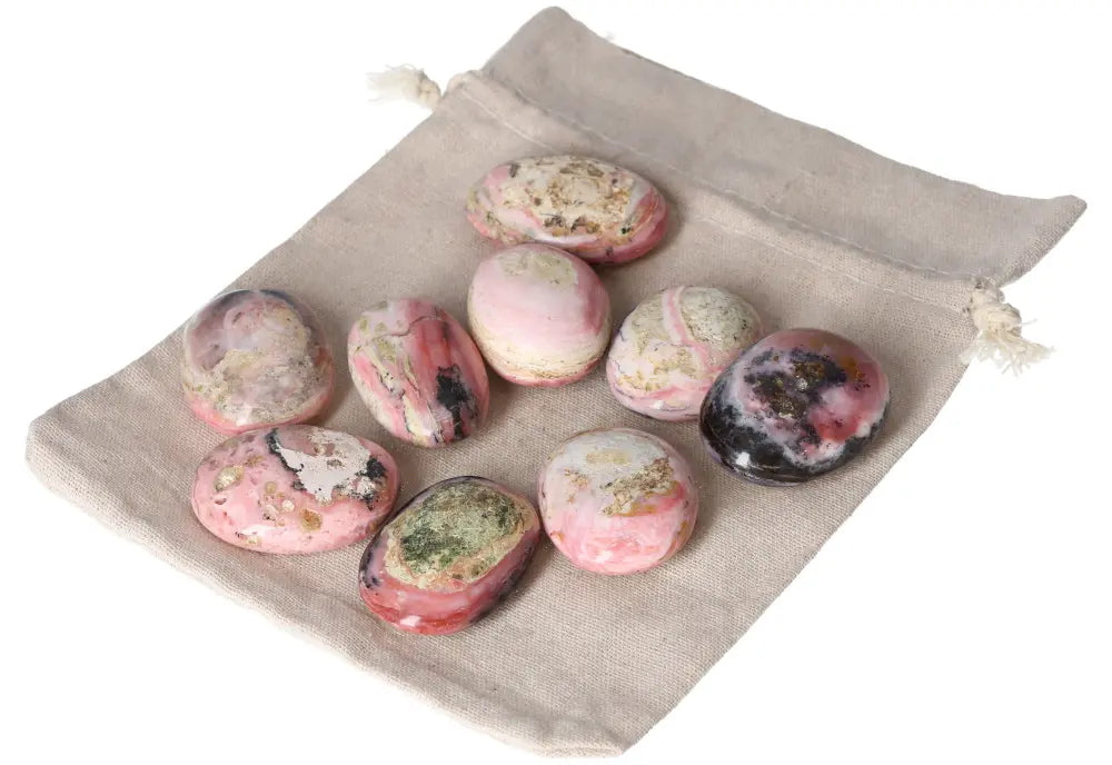 Collection of pink opal palmstones with soothing pink hues on a cloth bag, promoting emotional healing and personal transformation.