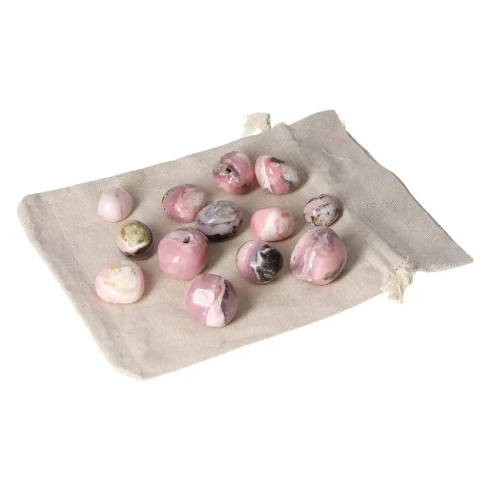 Pink Opal Tumbled gemstones in soft pastel shades on a beige cloth bag, ideal for emotional healing and personal transformation.