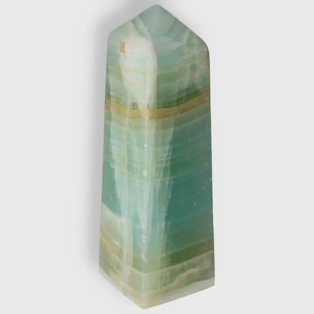 Pistachio Calcite Tower crystal with refreshing pale green hues for balance and harmony in home decor.