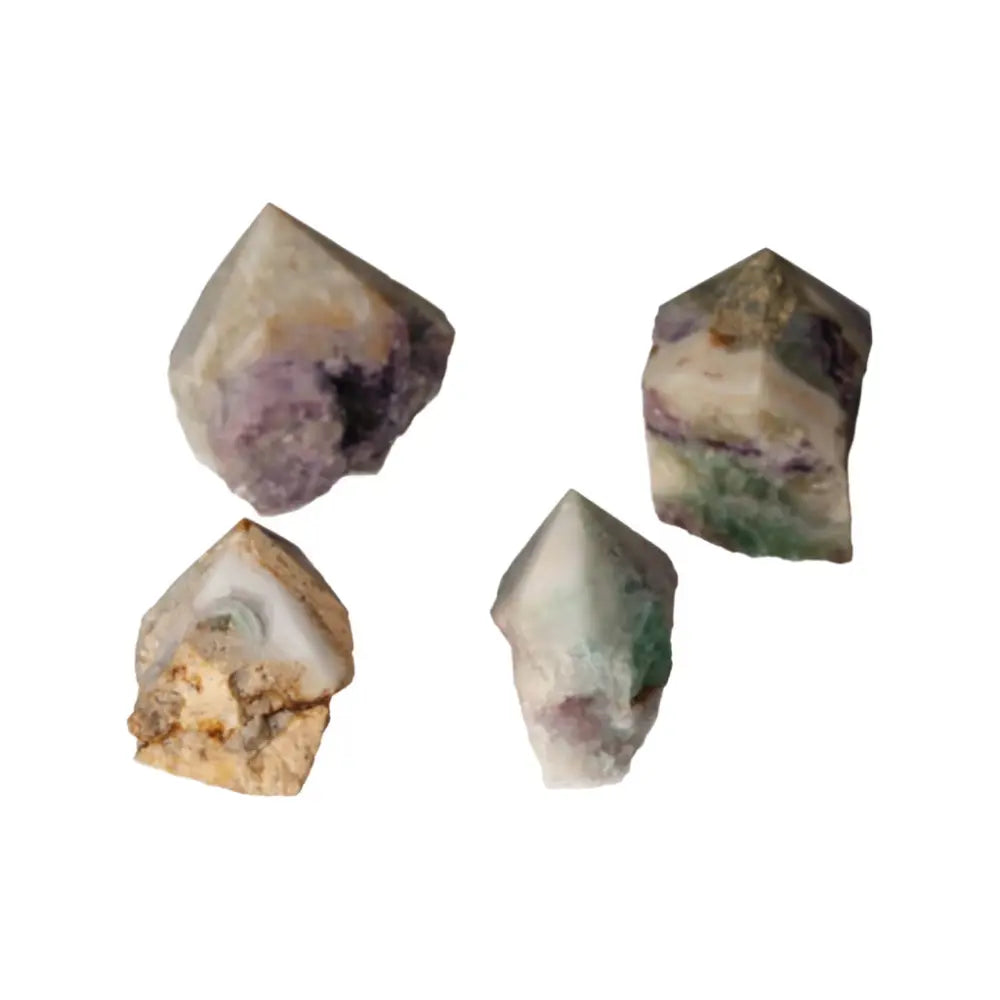 Four polished point fluorite crystals with varying hues from Sylvia Crystals, known for enhancing mental growth and spirituality.