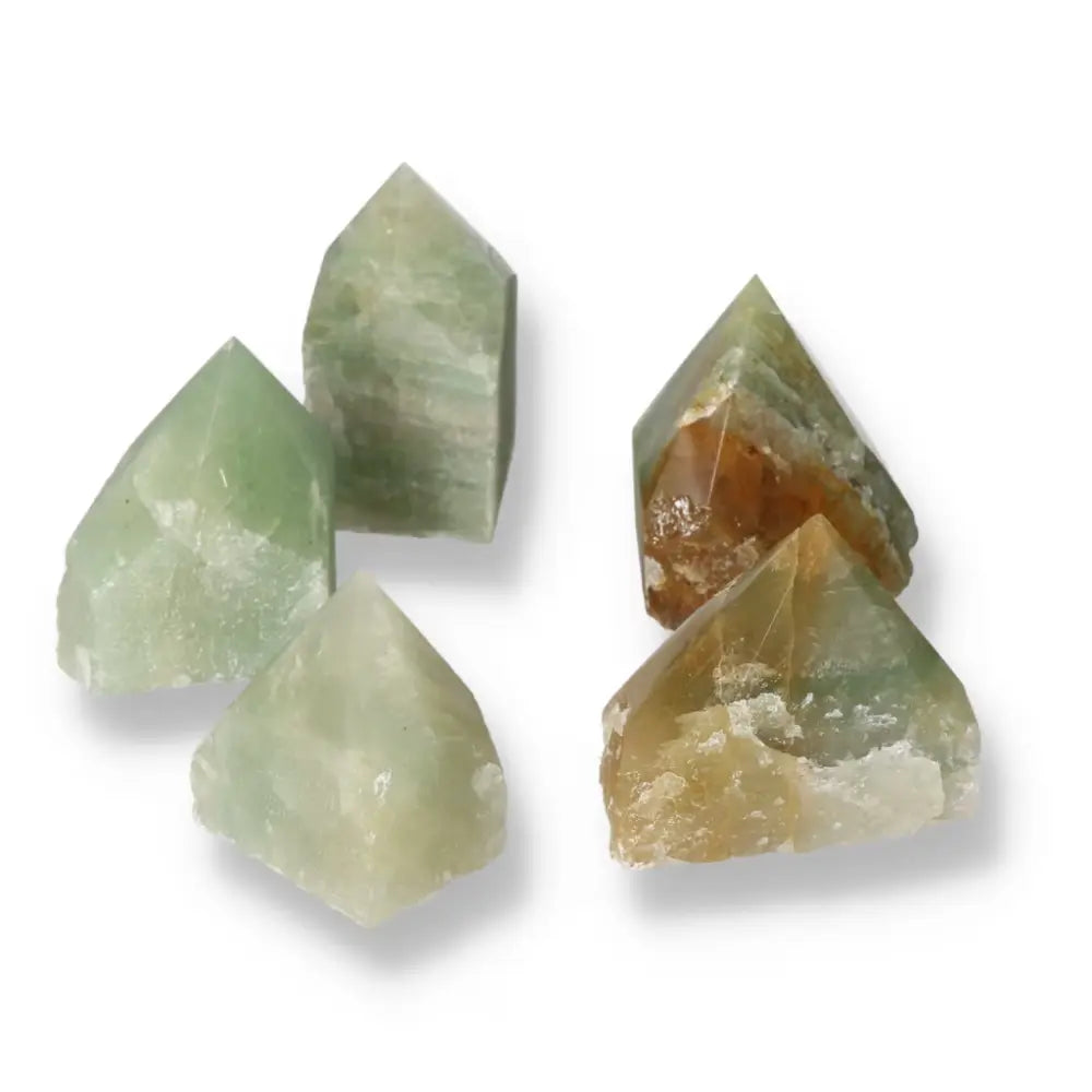 Assorted polished point gemstones including green quartz and hematite from Sylvia Crystals, showcasing luxury and craftsmanship.