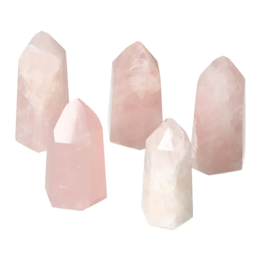 Five polished rose quartz obelisks showcasing gentle pink hues and crystalline elegance.