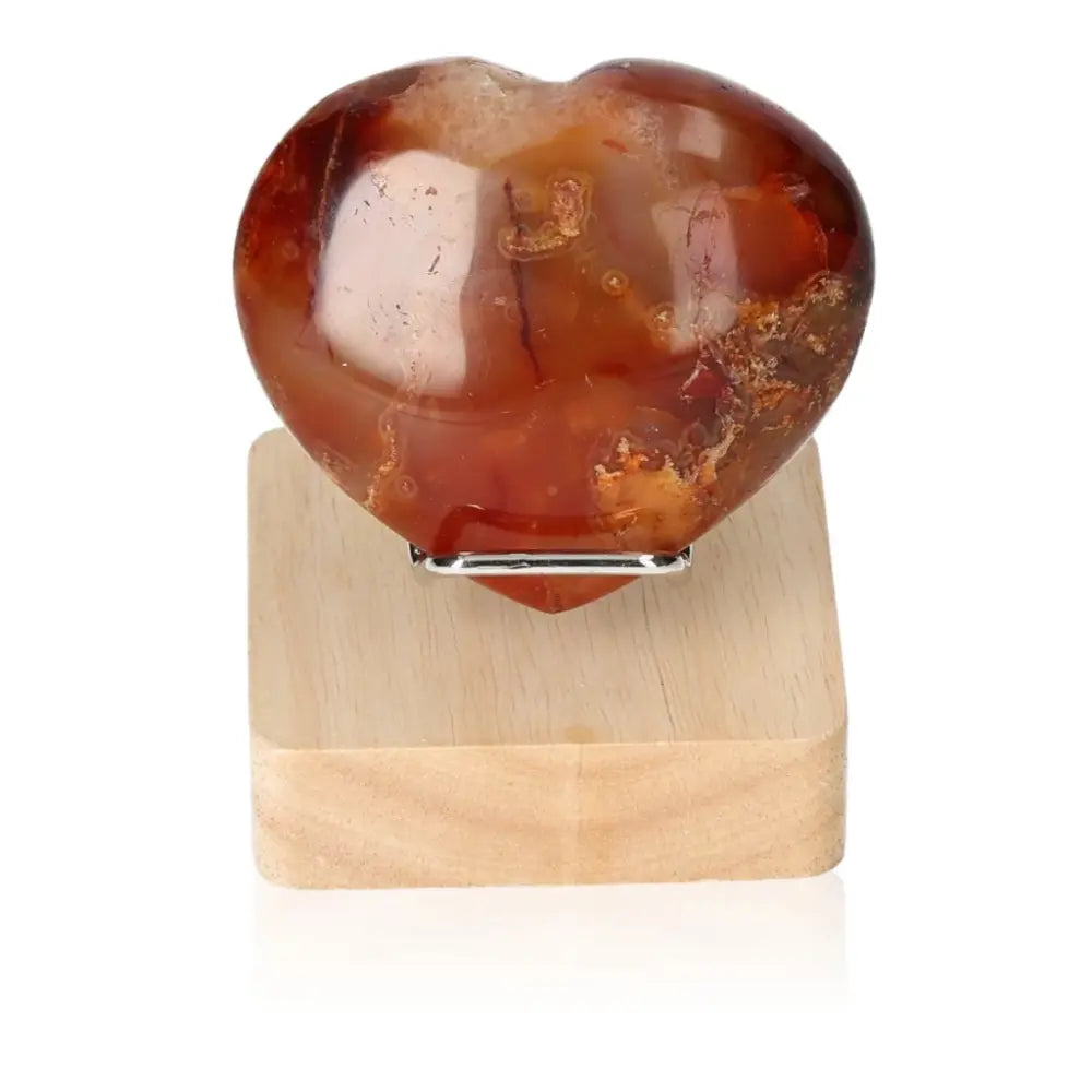Polychrome Jasper Heart with vibrant earth-tones displayed on a wooden stand, showcasing natural artistry and desert-inspired charm.