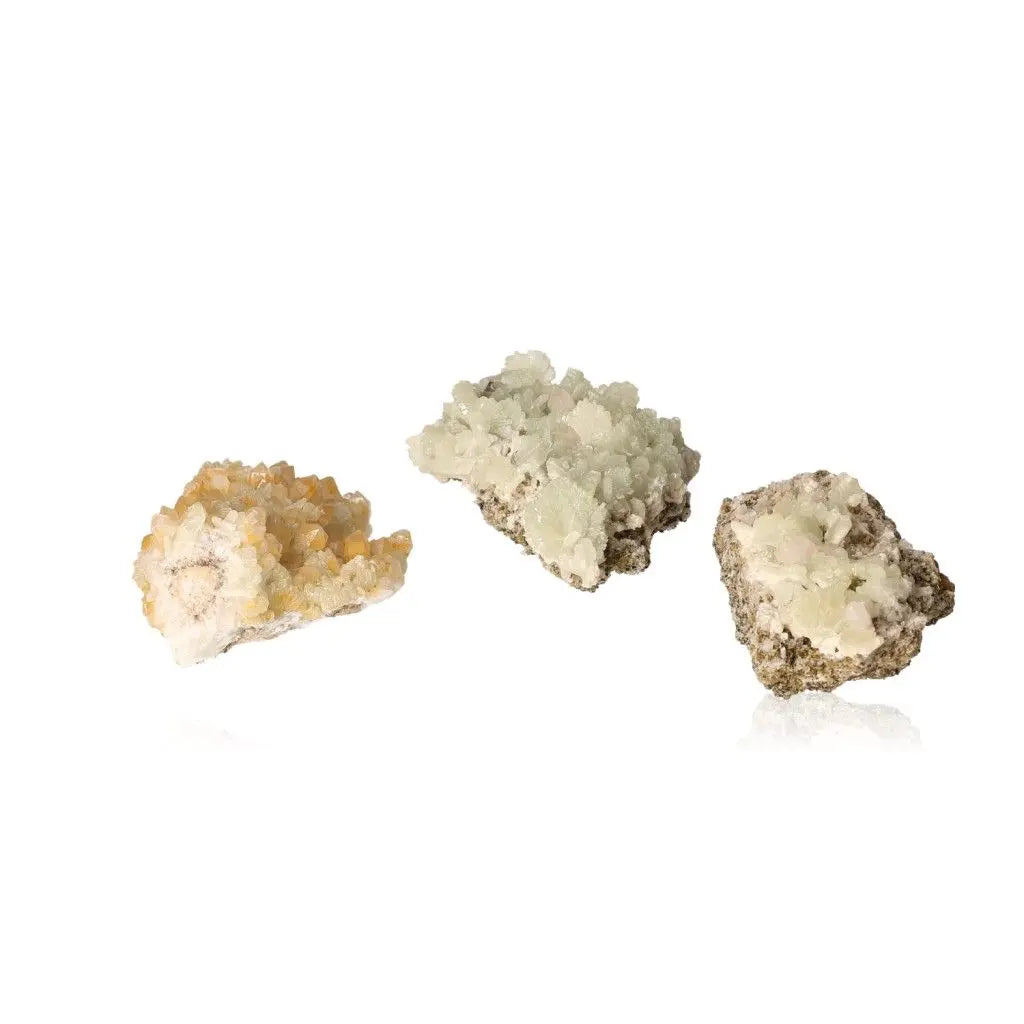 Three prehnite crystal clusters showcasing pale green and yellowish-green hues, embodying calming and spiritual growth properties.