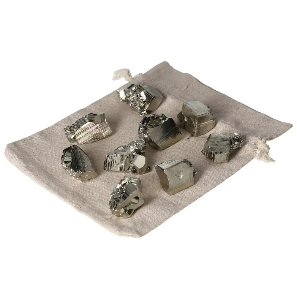 Collection of polished pyrite cubes on a beige cloth, showcasing golden luster and grounding energy.