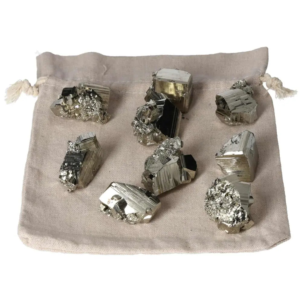 Pyrite cubes and clusters on a beige cloth pouch, showcasing their golden luster and unique crystal formations.