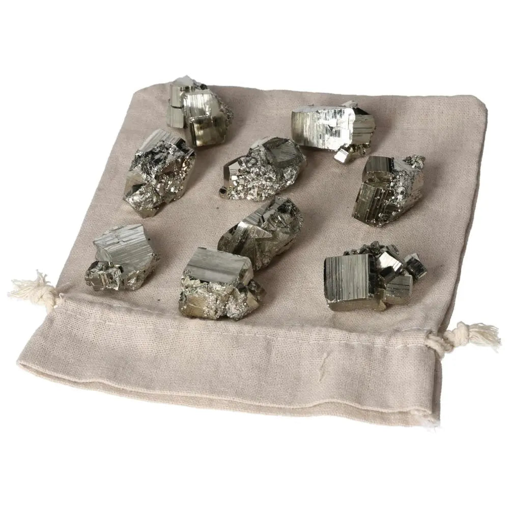 Natural pyrite stones on linen bag, showcasing golden luster and raw magnetic beauty, perfect for energy healing and decor.