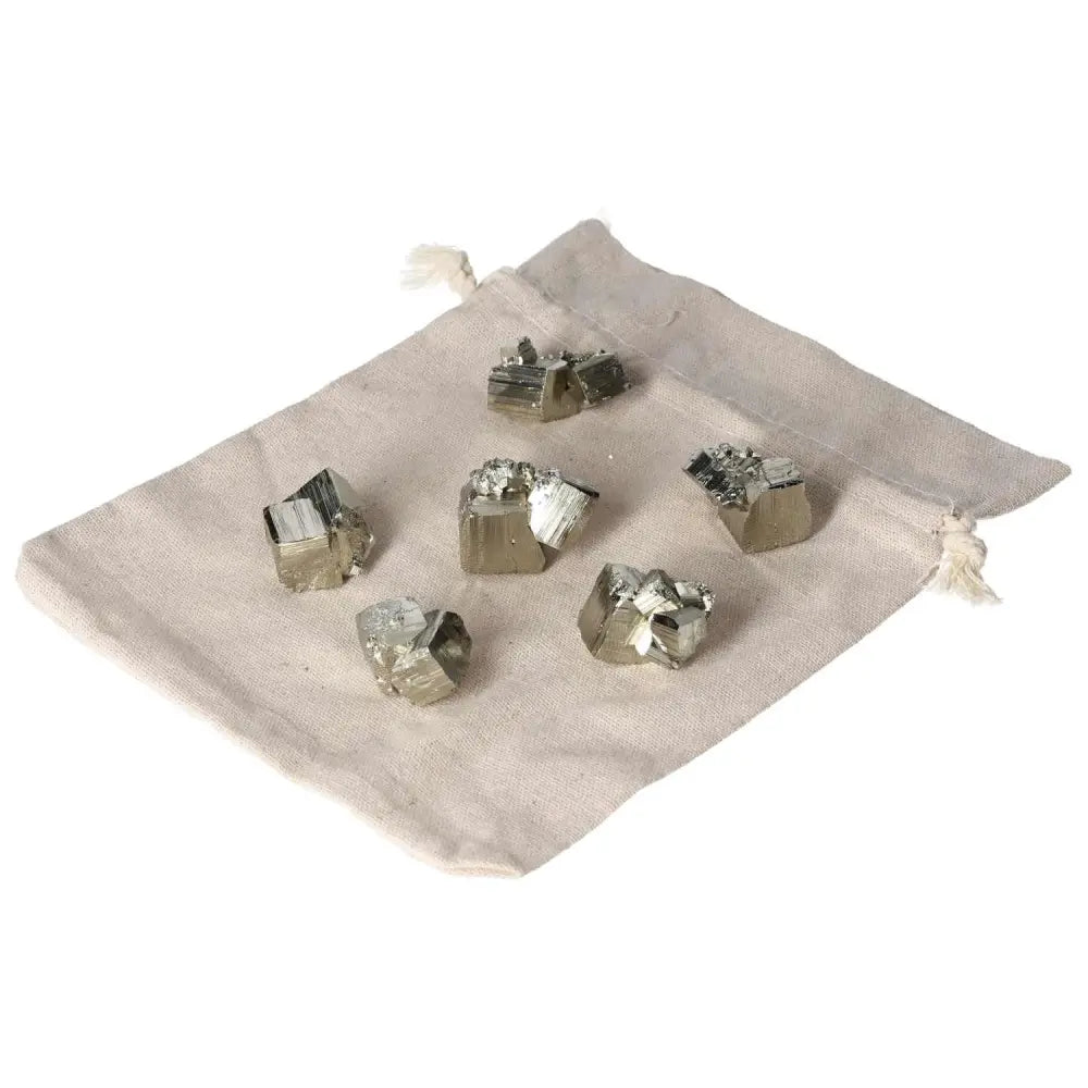 Polished pyrite cubes on a beige cloth, showcasing golden luster and grounding energy.