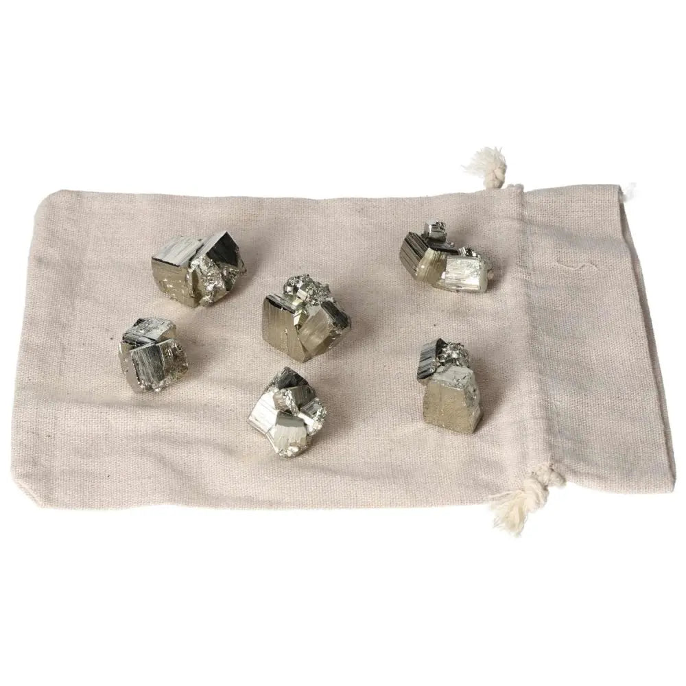 Collection of polished pyrite cubes on a cloth bag, showcasing golden luster and grounding energy for home decor and wellness.