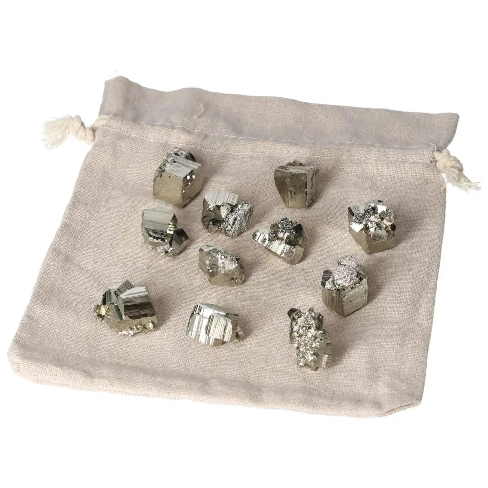 Assorted polished pyrite cubes on a cloth bag, showcasing golden luster and grounding energy for home decor and spiritual use.