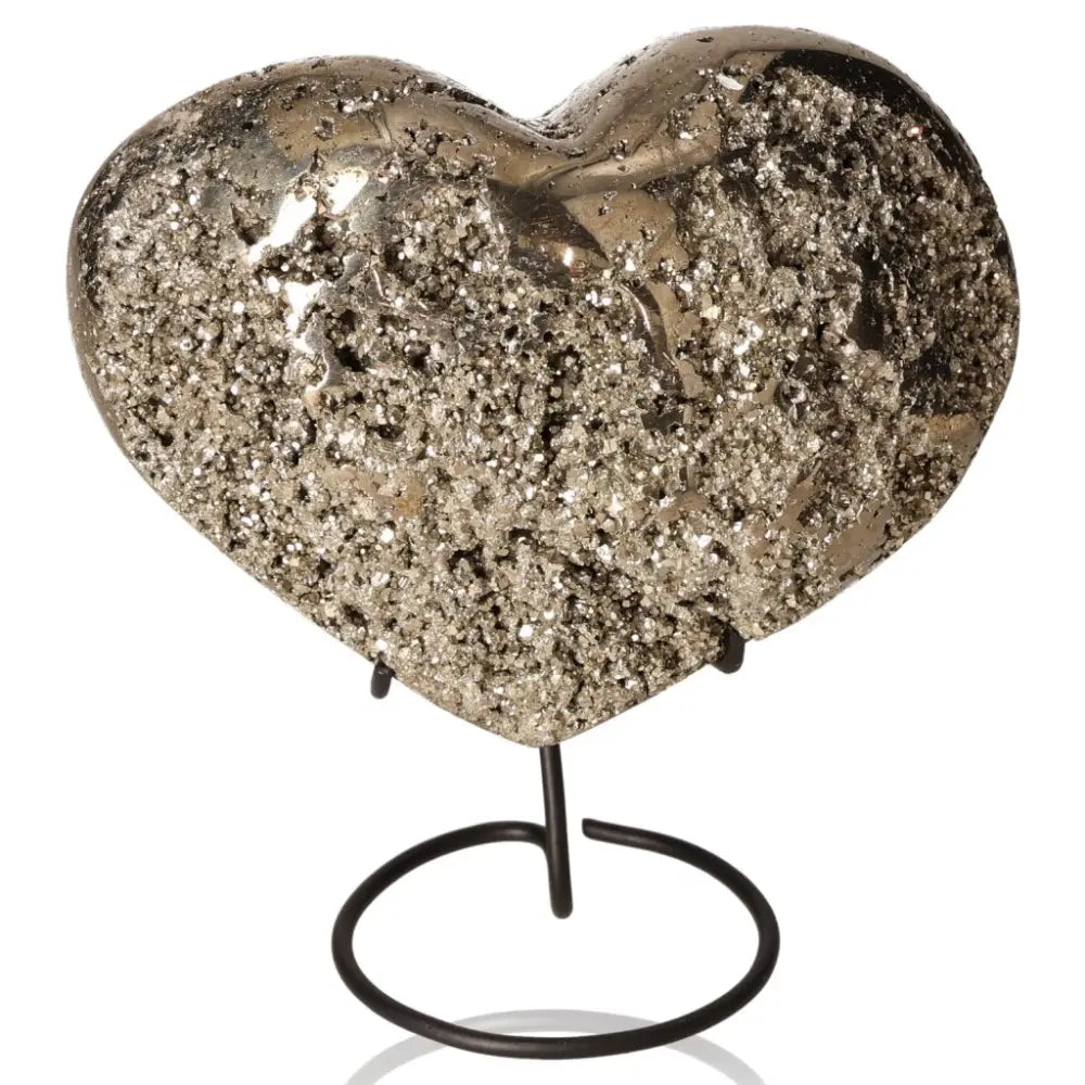Pyrite heart sculpture with metallic luster and golden hue, symbolizing abundance and prosperity on a black stand.