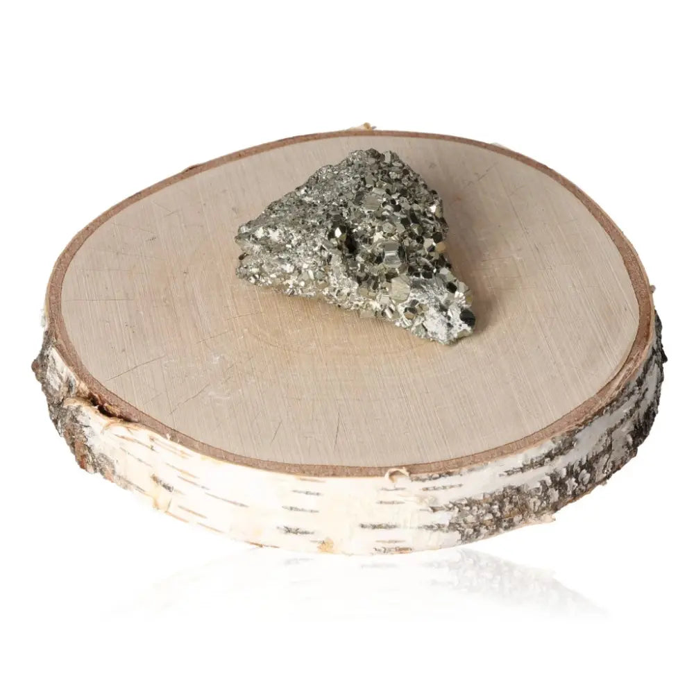 Pyrite druze gemstone with metallic luster displayed on a wooden slab, symbolizing prosperity and wealth.