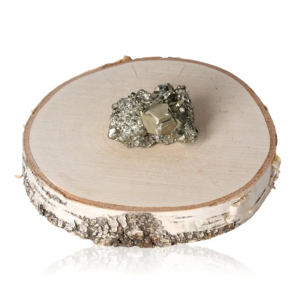 Pyrite druzy stone with a radiant metallic luster displayed on a natural birch wood slice.