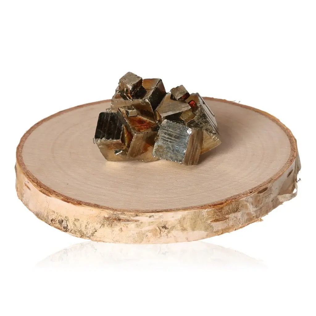 Pyrite druzes with metallic luster displayed on a wooden slab, symbolizing abundance and prosperity.