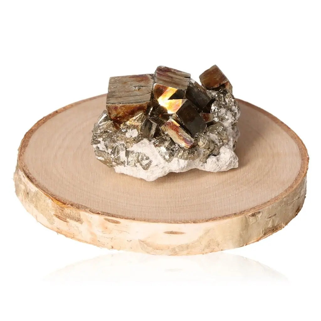 Pyrite druze with golden metallic luster placed on a wooden base, showcasing its resemblance to gold and believed to attract prosperity.