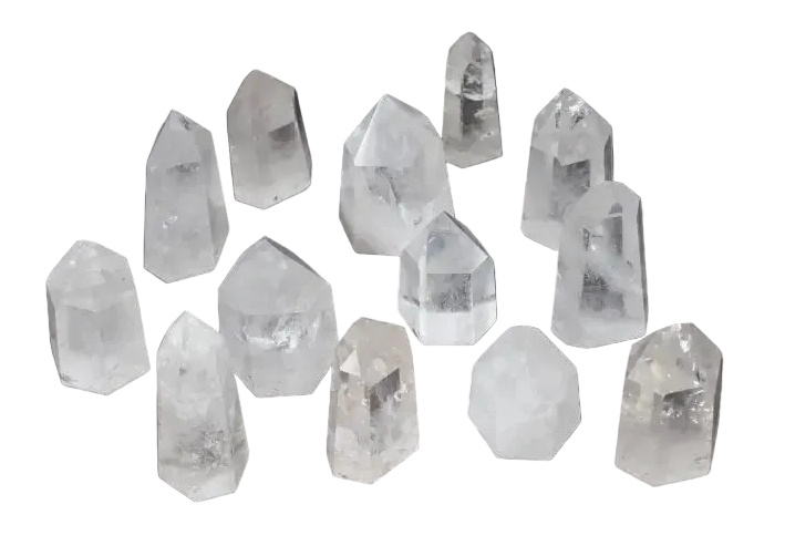 Collection of twelve clear quartz obelisks, each with unique shapes and clarity, displayed on a dark background.