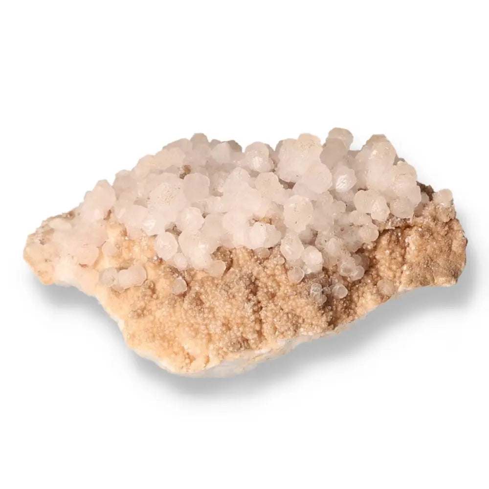 Natural quartz crystal cluster on beige rock for chakra energy alignment and holistic healing.