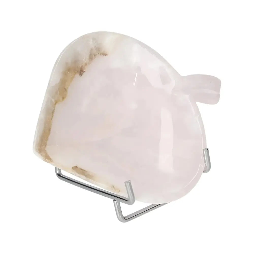 Delicate rose onyx platter with unique color variations, showcasing elegant beauty and smooth polished surface on a metal stand.