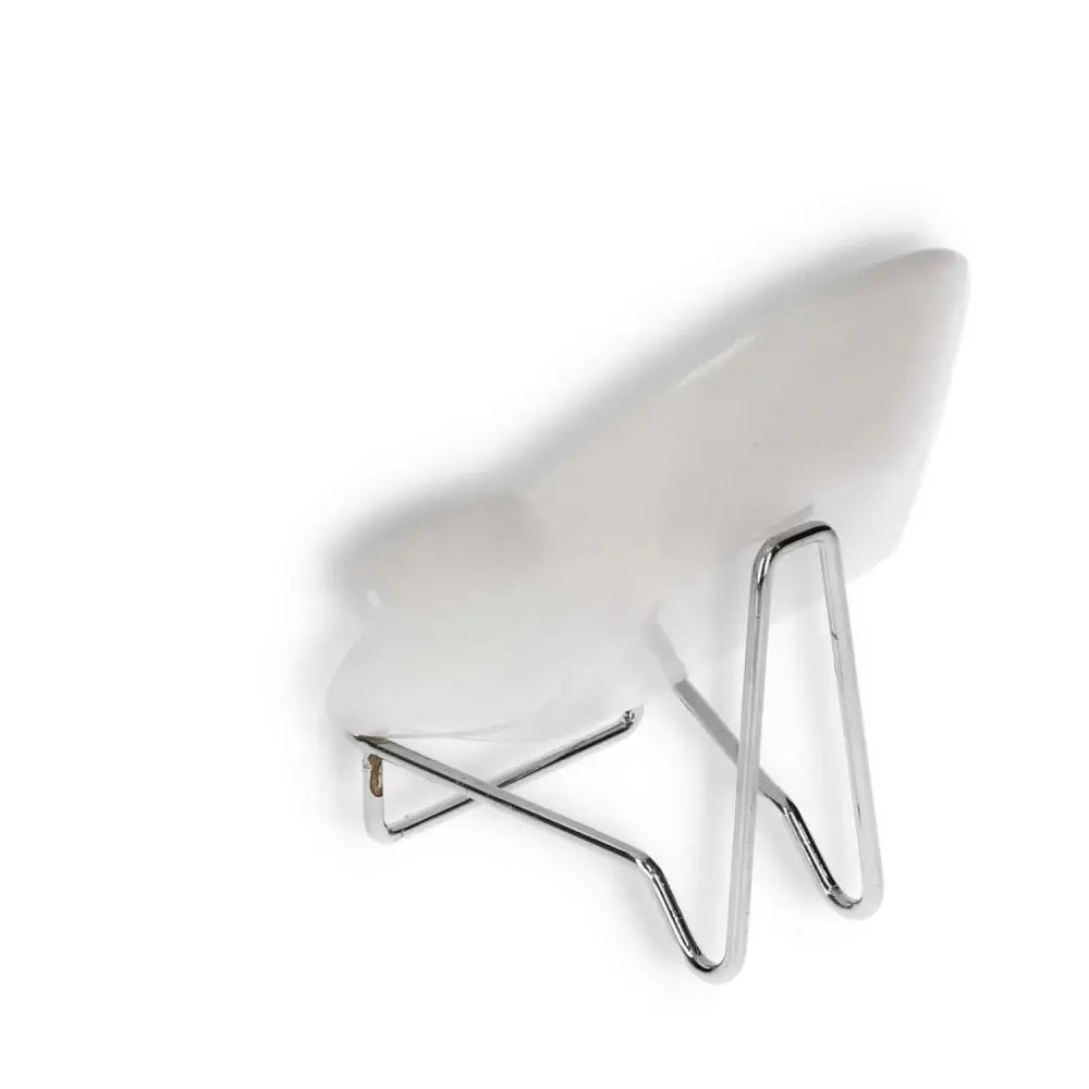 Modern minimalist chair with a curved white seat and sleek metal legs, designed for contemporary interiors.