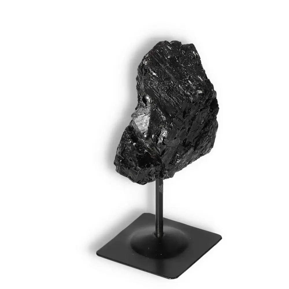 Rough Black Tourmaline on sleek metal stand, enhancing luxury decor and spiritual energy, from Sylvia Crystals collection.