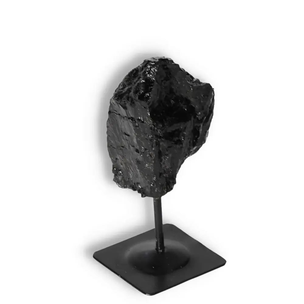 Rough Black Tourmaline with Metal Stand S for energy cleansing from Sylvia Crystals. Enhance serenity and balance with this exquisite crystal.
